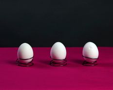 three eggs in metal holders