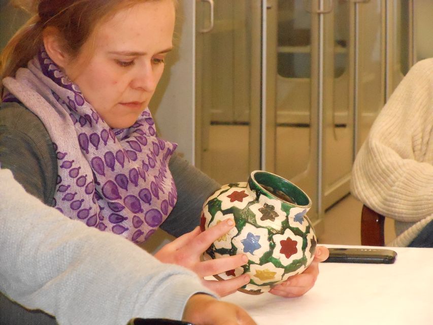 women looking at a ceramic pot