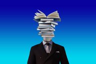 Computerized image of books stacked on a man's shoulders where a head should be