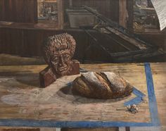 painting of sculpted head and bread sitting on table
