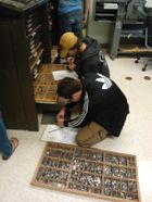 students with a drawer of metal type pieces
