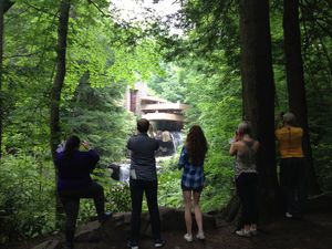 Students observing the Fallingwater building in the woods.
