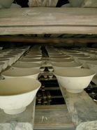 clay bowls drying on wooden beams