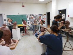 students carving clay heads